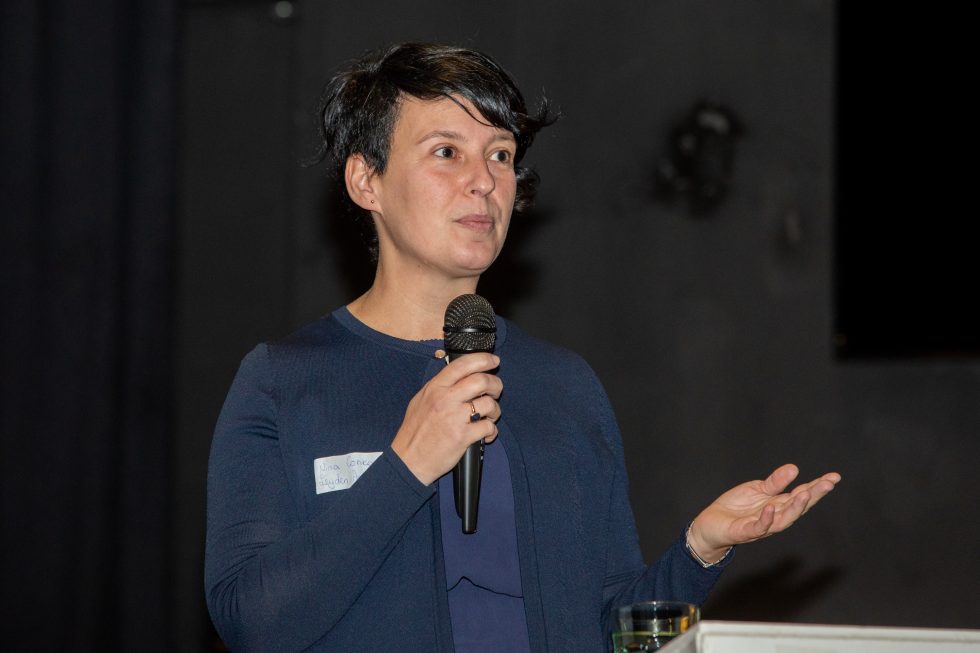 Spreker Nina Concova met een microfoon in de hand.