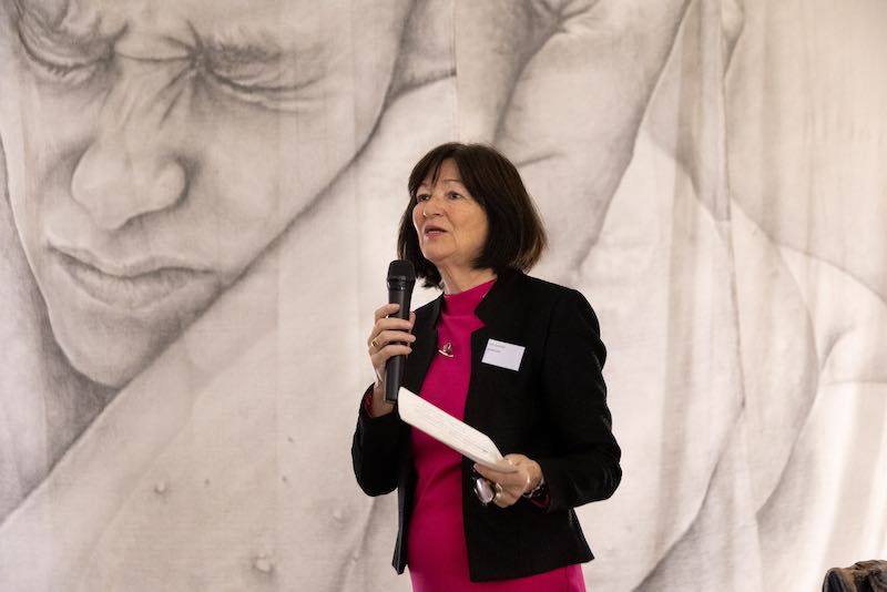 Karin Oppelland op het podium met een microfoon in haar hand.