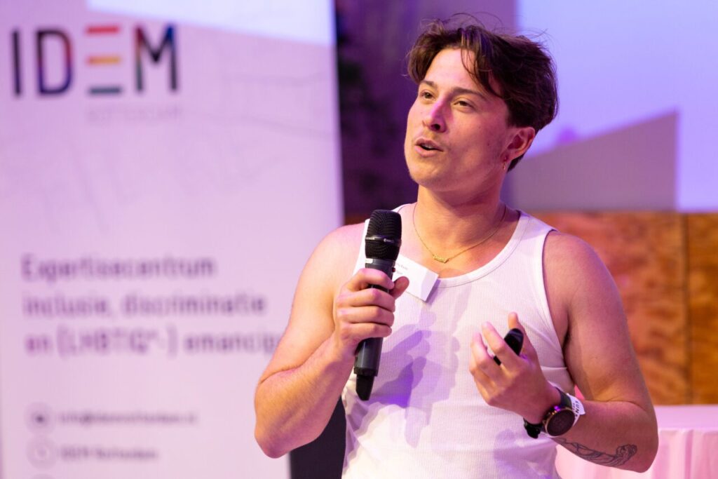 Een spreker houdt de microfoon vast terwijl die diens verhaal verteld.