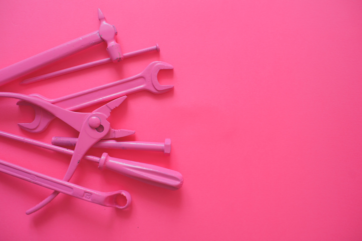 Veel verschillende kleuren roze gereedschap. Hamer, schroevendraaier, tang, verstelbare sleutel. 