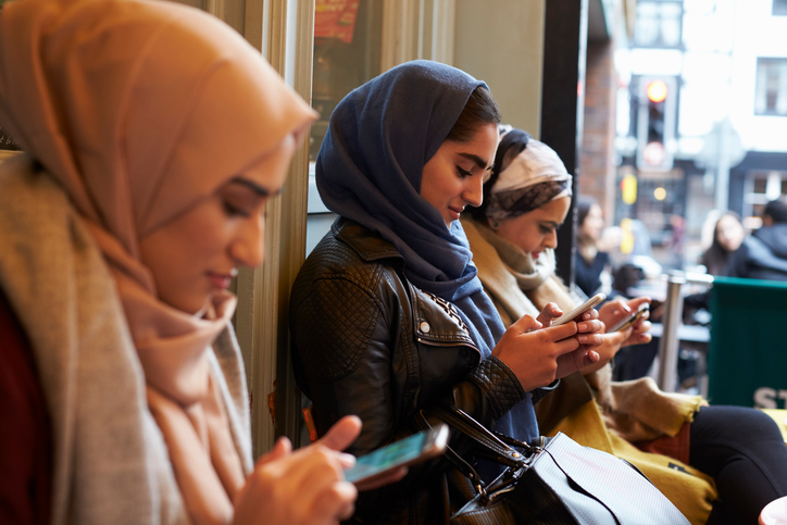 Groep Britse moslimvrouwen sms'en buiten de koffieshop