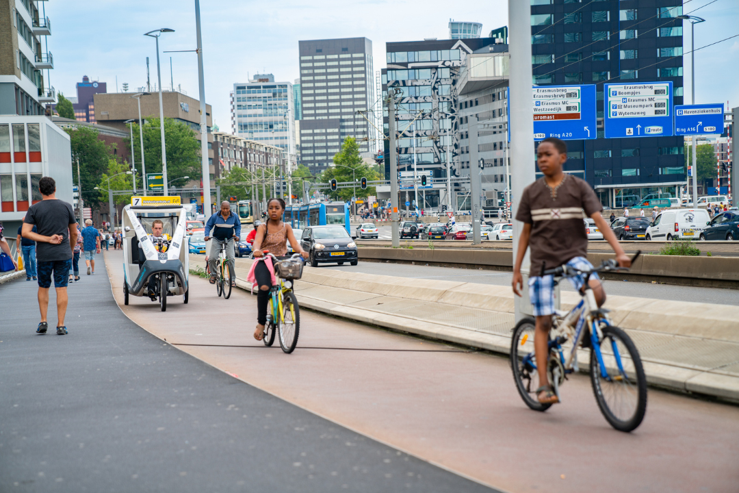Verschillende personen fietsen door het centrum van Rotterdam.