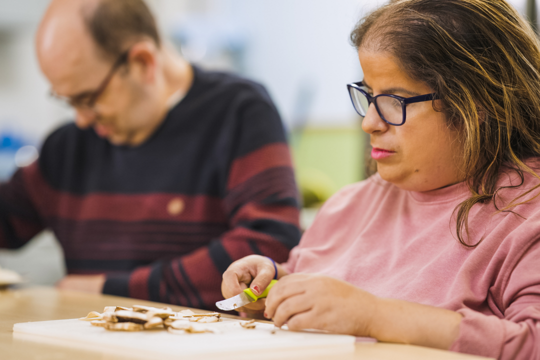 Twee personen met afstand tot de arbeidsmarkt zitten aan tafel en zijn eten aan het voorbereiden.